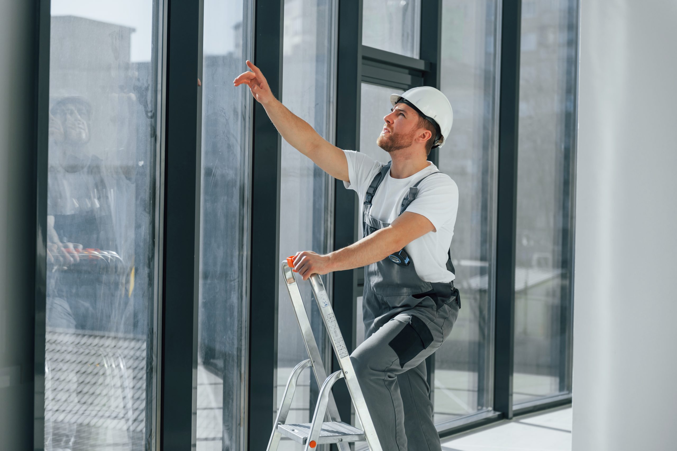 With leader near windows. Repairman is working indoors in the modern room.